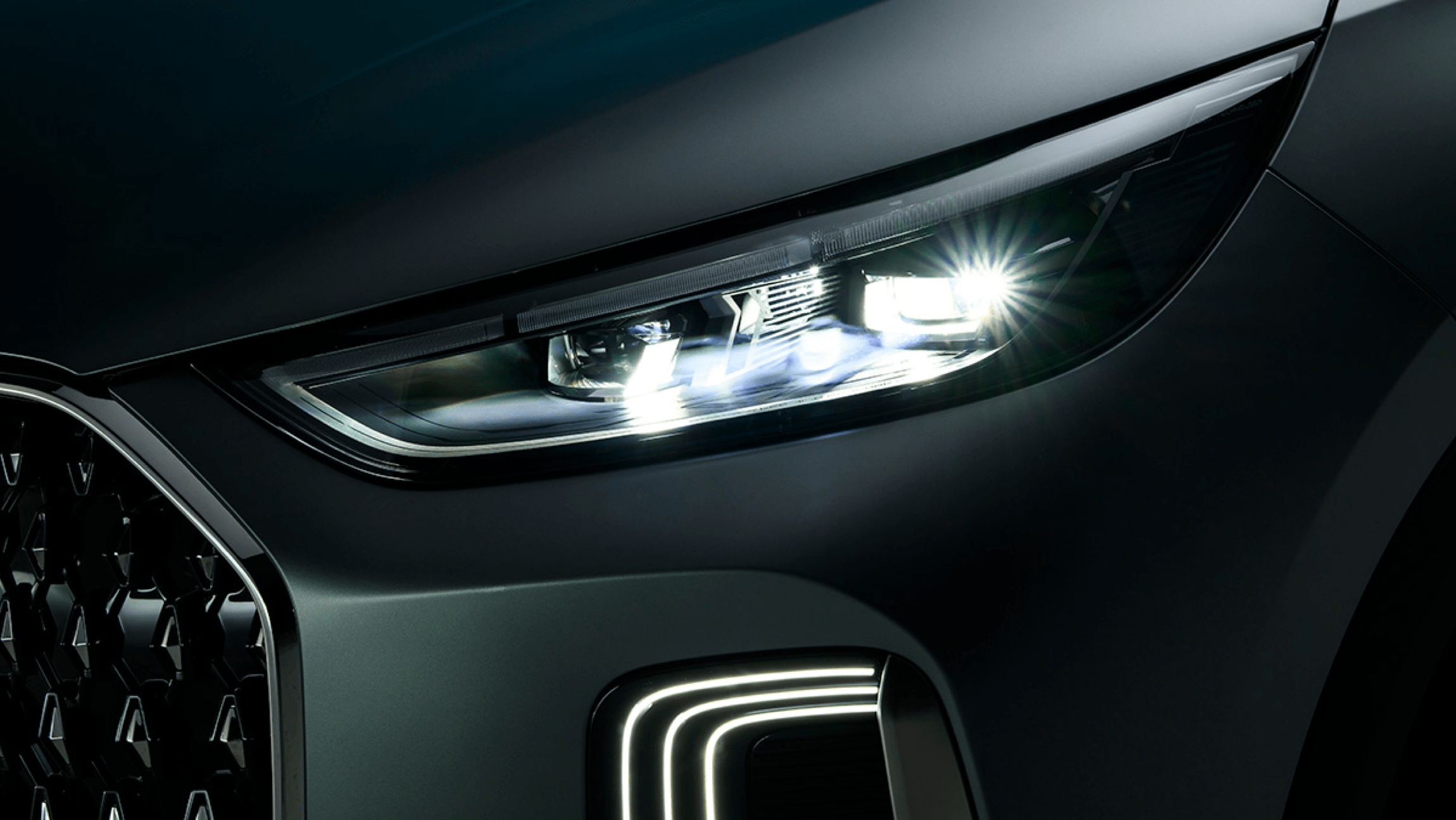 Close-up of Chery Tiggo 9 CSH front LED headlight illuminated