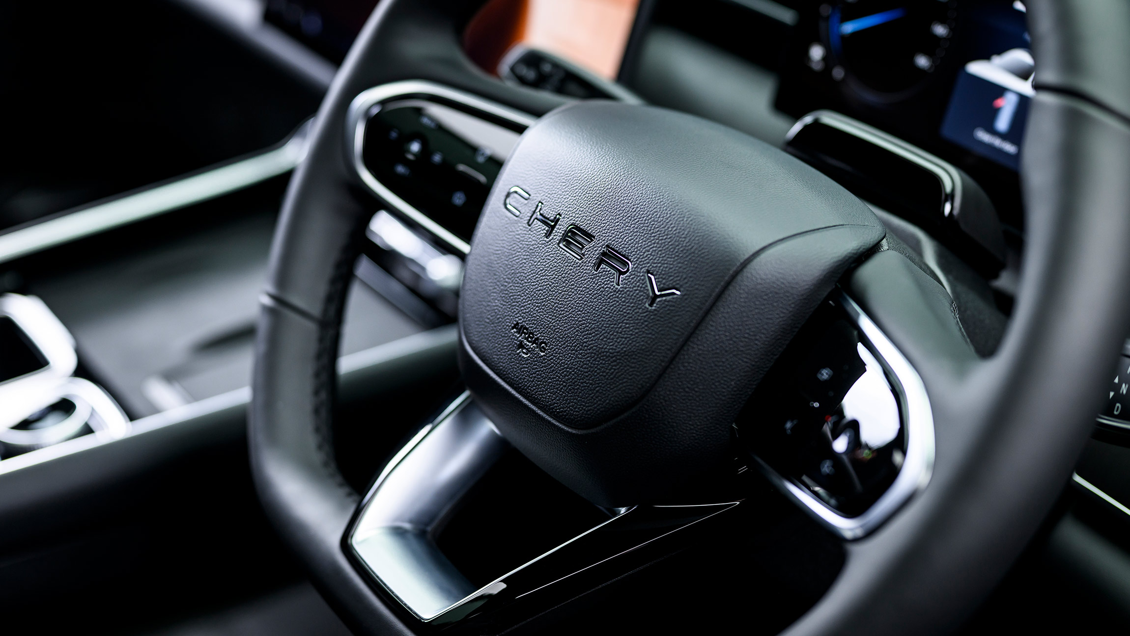Close-up of Chery Tiggo 9 CSH steering wheel in black leather with chrome accents