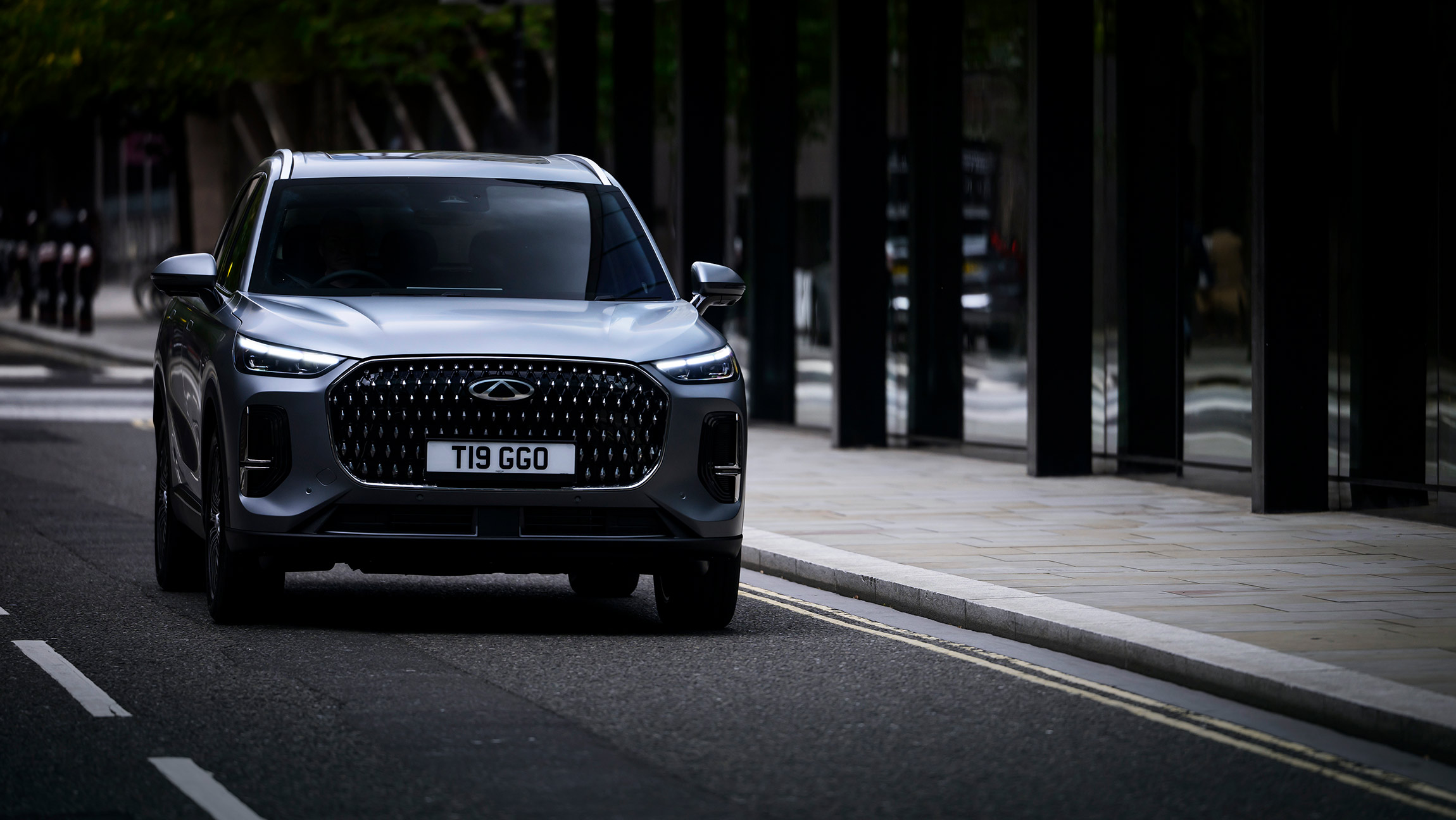 Chery Tiggo 9 CSH SUV in matte grey finish, driving on an urban street 
